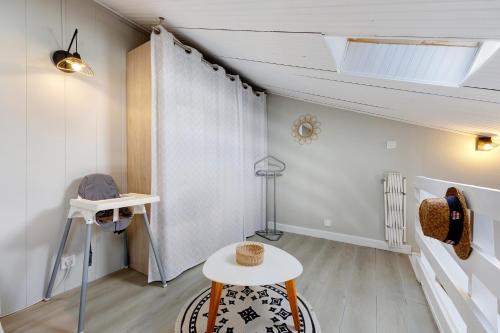 a room with a table and a white curtain at La Pause Iodée - 500 m mer in La Tranche-sur-Mer