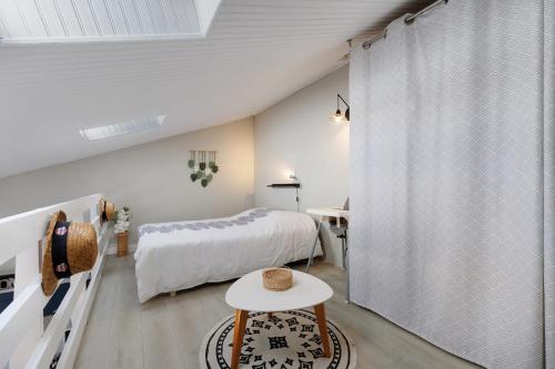 a bedroom with a bed and a table at La Pause Iodée - 500 m mer in La Tranche-sur-Mer