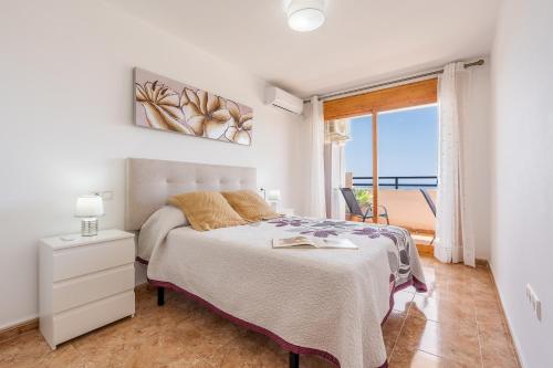 a bedroom with a bed and a view of the ocean at Piso Haza in Haza del Trigo