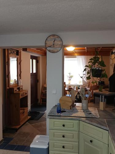 a kitchen and living room with a clock on the wall at Veronika in Wesenberg
