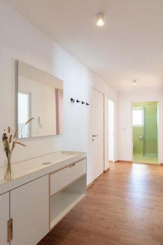 a white bathroom with a sink and a mirror at Hus Appartement - Nr. 5 in Valdaora