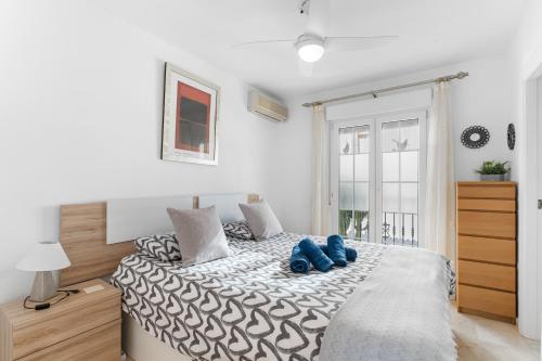 a bedroom with a large bed with blue pillows on it at Sunnygolfbeach in Orihuela Costa