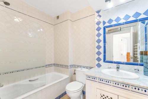 a bathroom with a tub and a toilet and a sink at Sunnygolfbeach in Orihuela Costa