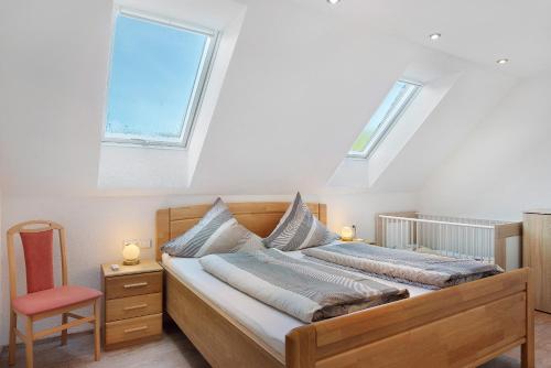 a bedroom with a large bed with two windows at Stockerhof in Elzach