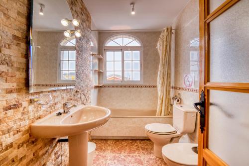 a bathroom with a sink and a toilet and a tub at Chalet Bonavista in Benifayó