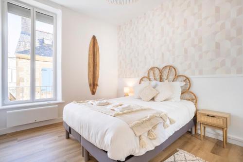 a white bedroom with a large bed with white sheets at Le nid des Perdrix in Île-Tudy