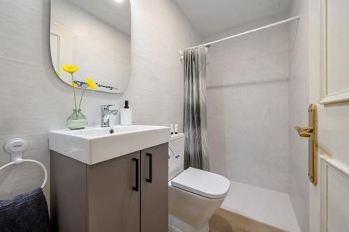 a bathroom with a sink and a toilet and a mirror at Habitació a Tarragona in Tarragona
