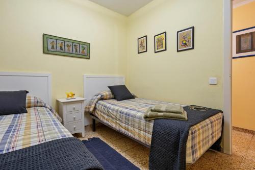 a bedroom with two beds and a night stand at Habitació a Tarragona in Tarragona