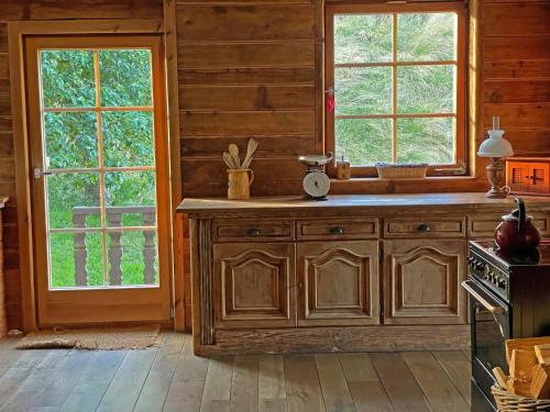 a kitchen with wooden cabinets and windows in a cabin at Schwarzwaldbauernhaus Bernau in Bernau im Schwarzwald