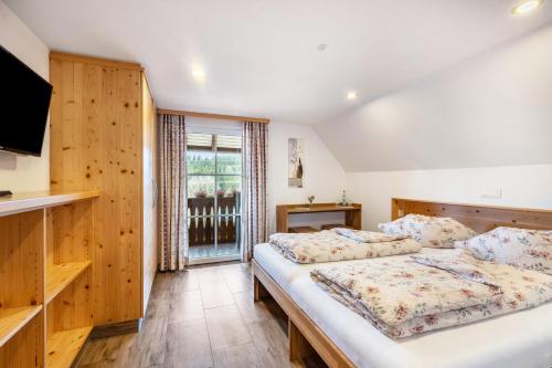 a bedroom with two beds and a tv at Das Schwarzwälder Speckhuisli in Grafenhausen
