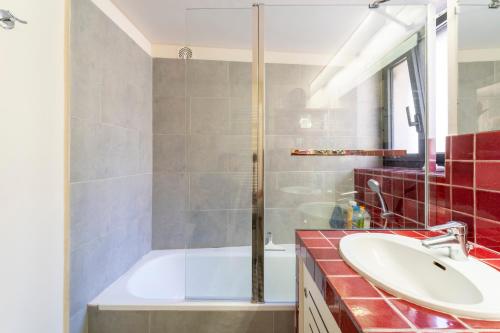 a bathroom with a tub and a sink and a shower at Le Sophora avec jacuzzi in Rochefort-du-Gard