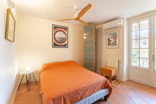 a bedroom with a bed and a ceiling fan at Le Sophora avec jacuzzi in Rochefort-du-Gard