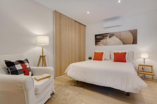 a white bedroom with a bed and a couch at Casa Jica in La Orotava