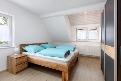 a bedroom with a bed with blue pillows at Ferienwohnung Weinbergblick in Auggen