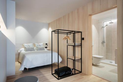 a bedroom with a bed and a bathroom with a shower at Ca Gracia Bocairent in Bocairent