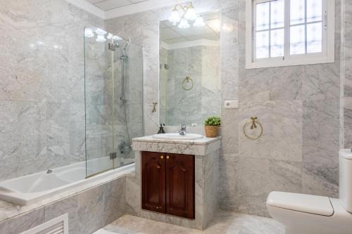 a bathroom with a sink and a shower and a toilet at Villa Candelaria Sol y Piscina in Bormujos
