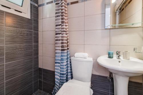 a bathroom with a toilet and a sink at Studio Aias in Póndi