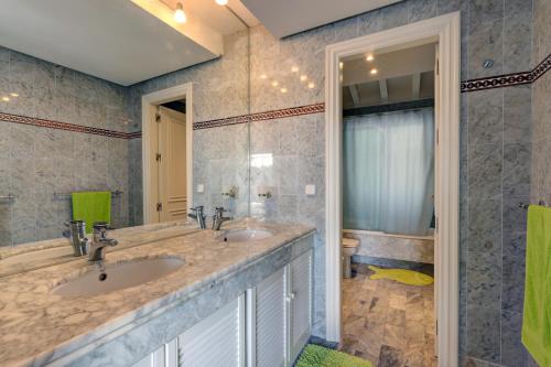 a bathroom with two sinks and a shower at Frontline paradise townhouse in Estepona