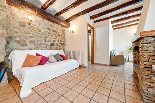 a bedroom with a white bed in a brick wall at Serra de Prades in Montblanc