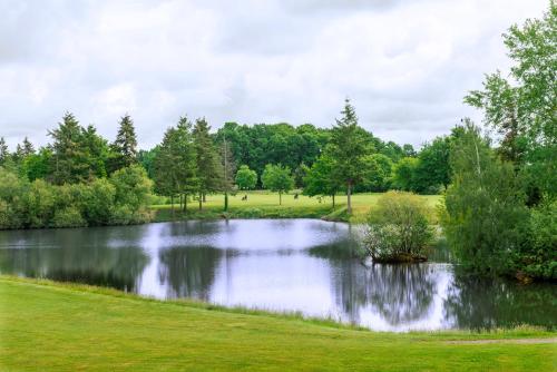 a pond in a park with trees in the background at Domaine de Cicé-Blossac, Resort Spa & Golf in Bruz