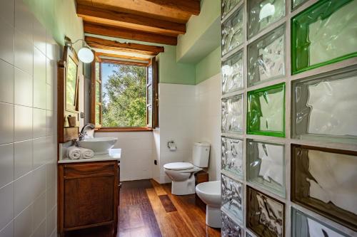 a bathroom with a toilet and a sink and a window at Casa da Penela in Mondoñedo