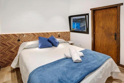 a bedroom with two beds with blue pillows at Casa Miranda 1 in Candelaria