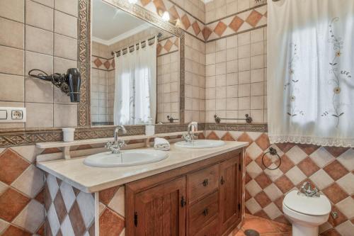 a bathroom with two sinks and a toilet and a mirror at Casa Carmelo 1 familas o parejas in Conil de la Frontera