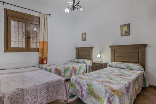 a room with two beds and a window at Casa Carmelo 1 familas o parejas in Conil de la Frontera