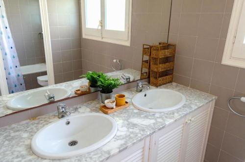 a bathroom with two sinks and a mirror at El Riu del Cel in Lloret de Mar
