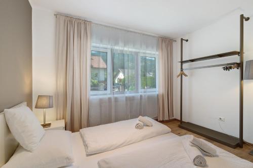 a bedroom with two beds and a window at Premium App Hofer Sandra in Villabassa