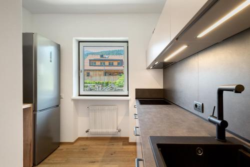a kitchen with a sink and a window on the wall at Premium App Hofer Sandra in Villabassa