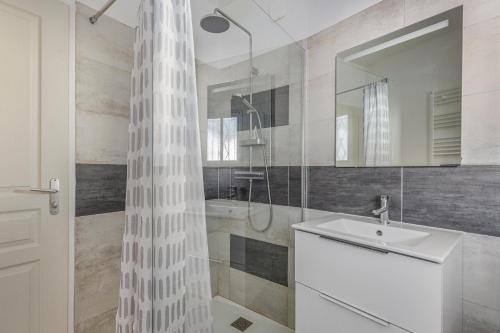 a bathroom with a white shower curtain and a sink at Le Relax 41 in Saint-Aignan