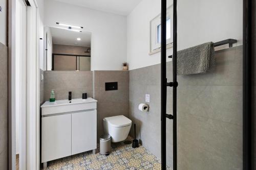a small bathroom with a toilet and a sink at Drop In Beach Apartments in Lourinhã