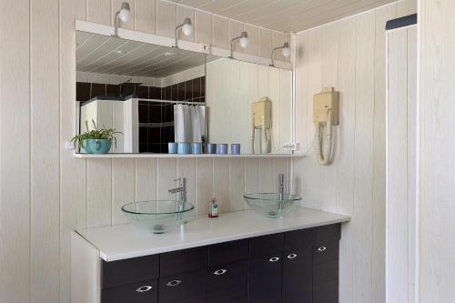 a bathroom with two sinks and a mirror at Gîte Bricabroc 2 adultes 2 enfants in Noyant