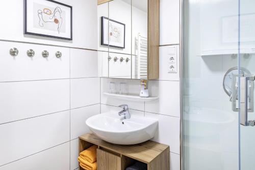 a white bathroom with a sink and a shower at Angie's Ferienapartment in Lichtenfels