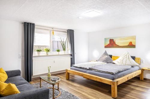 a living room with a bed and a couch at Angie's Ferienapartment in Lichtenfels