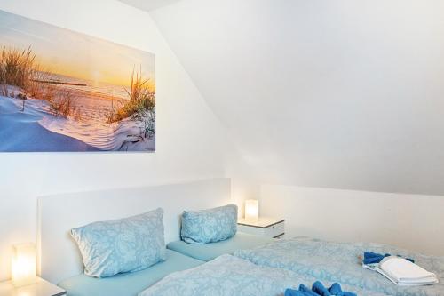 a bedroom with a bed and a painting on the wall at Meeresfeeling in Horumersiel in Horumersiel