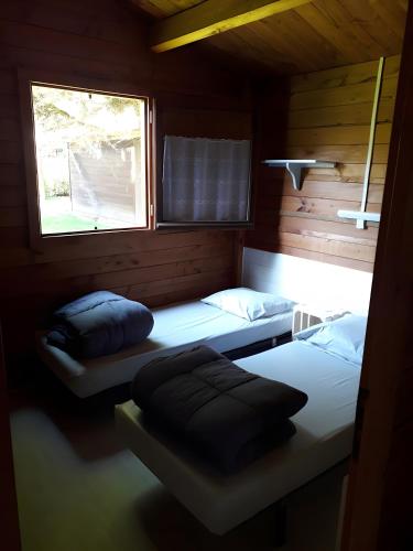 two beds in a room with two windows at Chalet bois 7 Domaine Les Epinettes in Saint-Gervais