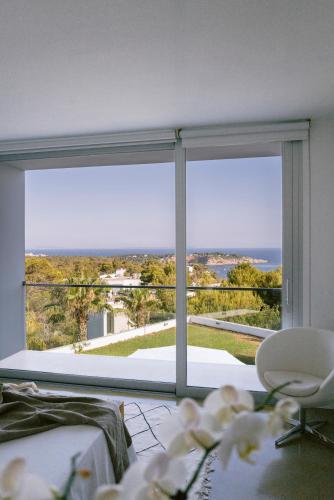 a room with a large window with a view of the ocean at Villa 10 9 in Sant Josep