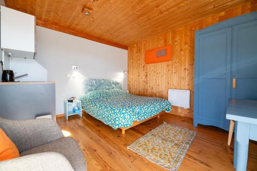a bedroom with a bed in a room with wooden walls at Cabane Ecolodge La Chastanha in Saint-Symphorien-de-Mahun