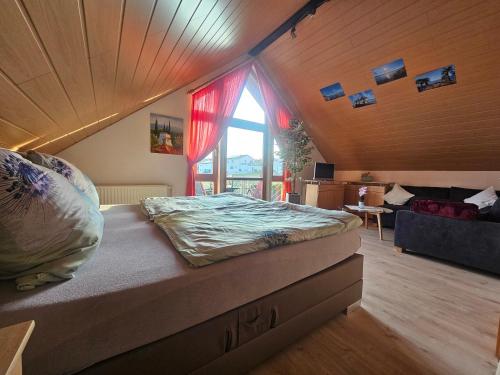 a bedroom with a bed and a large window at Haus Herdi-Schön in Herdwangen-Schönach