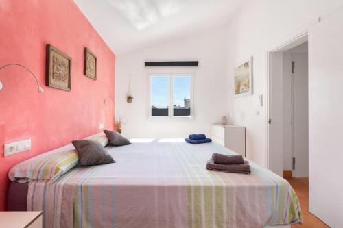 a bedroom with a large bed with a red wall at Villa Rose in Cala Blanca