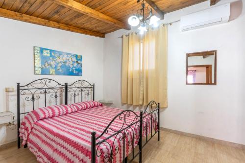 a bedroom with a bed with a red comforter at Villa Relax Due in Galatone
