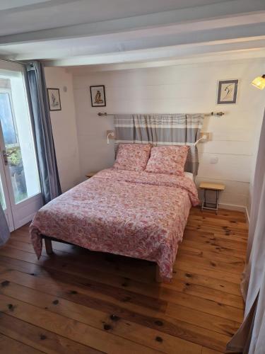 a bedroom with a bed with a red comforter at La Farigoulette in Aniane