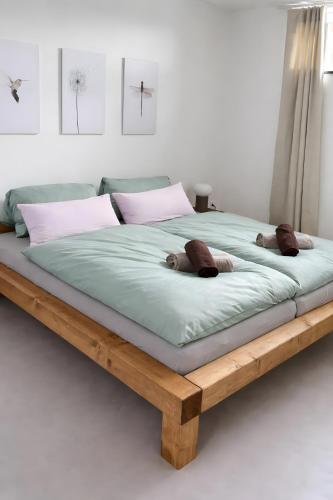 a large wooden bed with two teddy bears on it at Hygge Home Schwarzwald in Villingen-Schwenningen