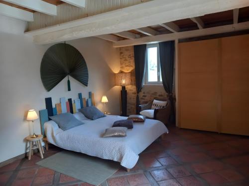a bedroom with a large bed with blue pillows at Les Vallons du Lot in Gorses