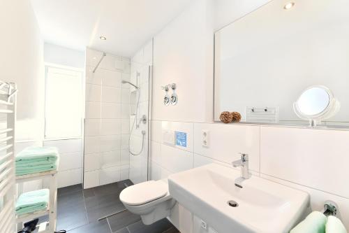a white bathroom with a sink and a toilet at Dinkelbach Traumblick 3 C in Hengnau