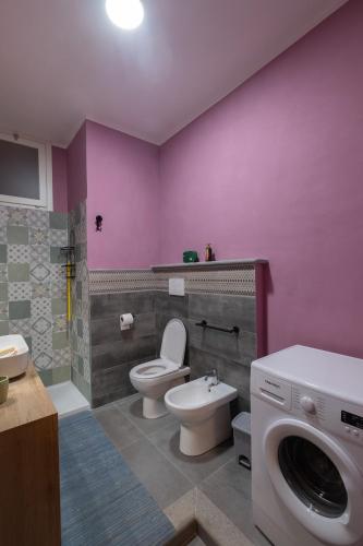a bathroom with a toilet and a sink and a washing machine at Casa Monet 90 wifi-parking in Capodimonte