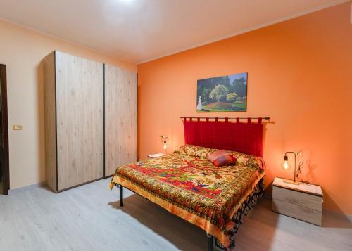 a bedroom with a bed and an orange wall at Casa Monet 90 wifi-parking in Capodimonte