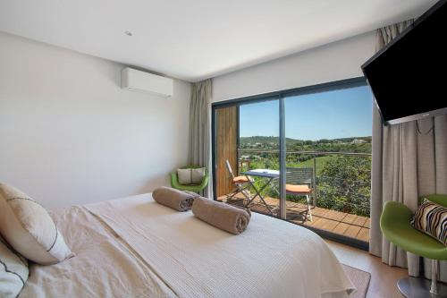 a bedroom with a bed and a balcony with a view at Tiny House in São Brás de Alportel